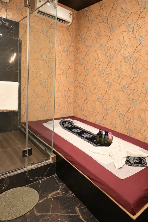Therapy room with attached glass shower at Anantram Spa